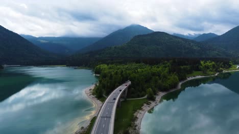 Aerial-Drone-Shot-of-Turquoise-Blue-Lake-with-Mountain-and-Bridge-in-German-Bavaria-Area---Sylvenstein-Lake-and-Aussicht-Faller-Klamm-Brücke