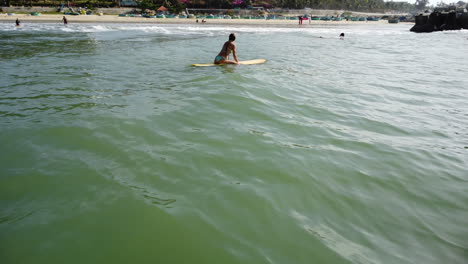 Junge-Kaukasische-Athletische-Surferin-Wartet-Auf-Perfekte-Wellen,-Während-Sie-Auf-Einem-Gelben-Brett-In-Der-Tropischen-Strandmeerlandschaft-Des-Ozeans-Surft