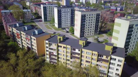 Aerial-view-of-crowded-residential-district-apartment-buildings-on-a-sunny-summer-day,-renovated-and-insulated-houses,-colorful-walls-of-the-facade,-wide-angle-point-of-view-drone-shot-moving-left