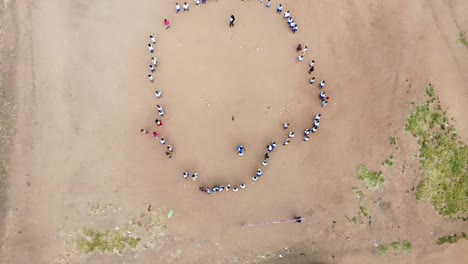 African-School-Playground,-Kids-Standing-in-Circle-and-Playing-Game,-Aerial-View