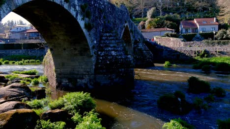 Aerial-View-Of-Stone-Arches-Of-Bridge-of-Ponte-Maceira-Over-The-River-Tambre