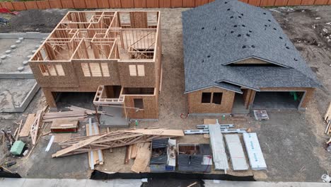Panning-aerial-shot-of-three-homes-in-different-stages-of-construction
