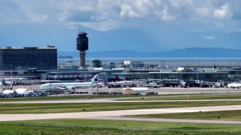 Airplanes-On-The-Airfield-And-Air-Traffic-Control-Tower-Of-YVR-Vancouver-Airport-In-Canada
