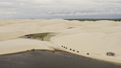 Drohnenkran-Bewegung-Einer-Gruppe-Auf-ATV-Fahrzeugen,-Die-Entlang-Der-Brasilianischen-Sanddünen-Fahren