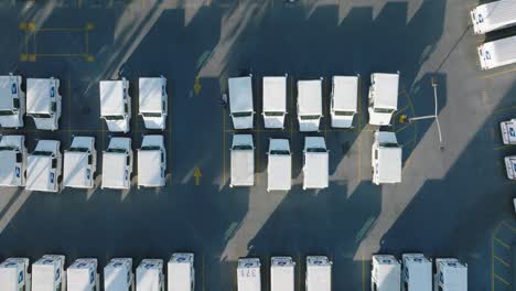 Luftaufnahmen-Von-Geparkten-USPS-Lastwagen-Und-Auf-Dem-Parkplatz-Geparkten-Postdienstwagen-Der-Vereinigten-Staaten,-Aus-Sicht-Der-Drohne