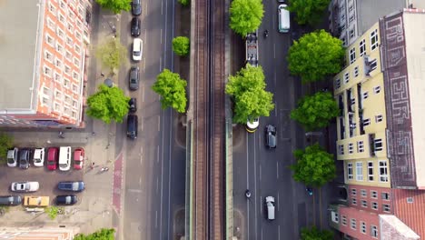 Camera-tracks-cars-and-streetcar,-ends-with-a-panorama-of-the-TV-tower-Great-aerial-view-flight-tilt-up-drone-footage-of-Berlin-Prenzlauer-Berg-Schönauer-Allee-Spring-2022-Cinematic-by-Philipp-Marnitz