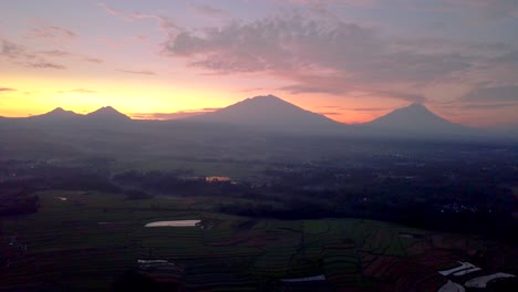 View-of-Merapi-volcano-and-mounts-Merbabu,-Andong-and-Telemoyo-during-a-colorful-pink-and-orange-sunrise
