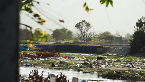 Verschmutztes-Flussufer-Mit-Plastikmüll-In-Einem-Land-Der-Dritten-Welt