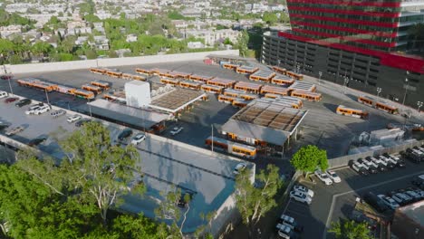 Bus-Parking-Lot-Beside-Pacific-Design-Center,-Aerial-Footage-Over-Parking-Lot-Full-of-Buses