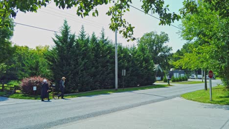 Una-Pareja-De-Ancianos-Amish-Caminando-Por-La-Calle-En-Un-Camino-Rural