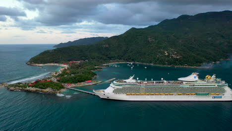 Drone-shot-of-cruise-ship-docked-in-the-Hatai-with-coastal-mountains-in-the-background