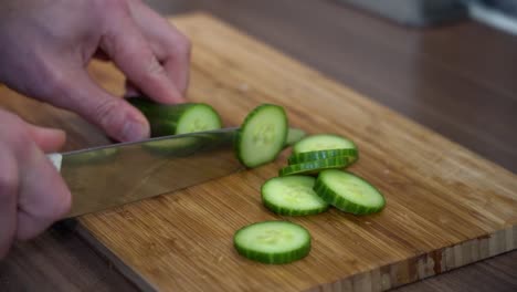 Cutting-cucumber-slow-motion---slow-motion-of-slices---clean-green-and-juicy---wooden-board