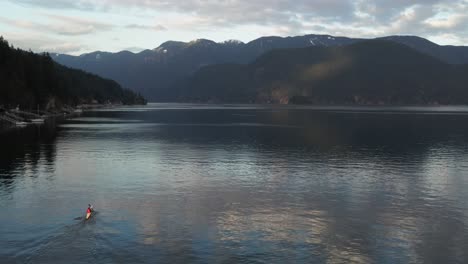 Vista-Aérea-De-Una-Persona-Remando-En-Kayak-En-Un-Lago-En-El-Norte-De-Vancouver,-Columbia-Británica