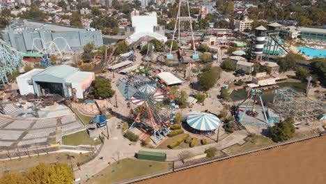 Daytime-Aerial-View-Of-Amusement-Park-Rides-At-Costa-Park-Along-Lujan-River-In-Tigre-City,-Buenos-Aires,-Argentina