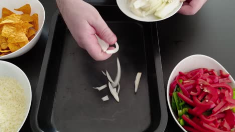 Placing-Sliced-White-Onions-In-A-Baking-Tray