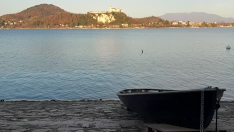 Romantischer-Blick-Auf-Ein-Boot-Außerhalb-Des-Wassers-Mit-Der-Festung-Angera-Im-Hintergrund