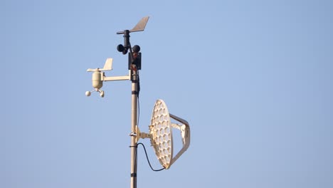 Home-weather-station-spins-in-the-wind-against-a-blue-sky-background