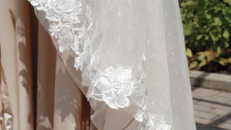Gorgeous-details-of-a-white-and-skin-colored-designer-wedding-dress-outside-in-the-garden