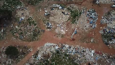 Aerial-view-of-a-landfill-with-piles-of-trash-scattered-all-over-the-site---bird's-eye-view