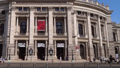 Slow-pan-across-front-of-famous-Burgtheater-in-Vienna-with-Fiaker-horse-cart