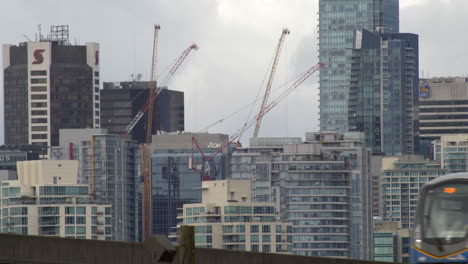 View-of-buildings-with-construction-cranes-on-cloudy-day