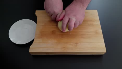 Close-up-on-hands-cutting-onion.-High-angle