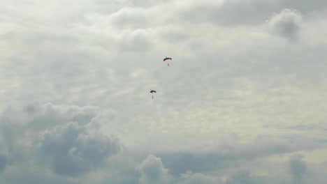 Zwei-Einzelne-Fallschirmspringer-Gleiten-Mit-Geöffnetem-Fallschirm-Langsam-Zur-Erde
