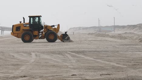 Caterpillar-wheel-loader-leveling-sand-to-repair-damage-to-the-beach-and-dunes