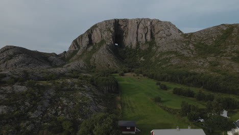 Casa-De-Campo-Con-Campos-Verdes-Al-Pie-De-La-Montaña-Torghatten-En-La-Isla-Torget-En-Bronnoy,-Nordland,-Noruega