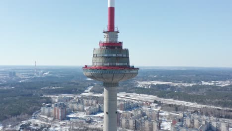 Close-Up-Aerial-Drone-Shot-of-Vilnius-TV-Tower-with-City-and-Forest-in-Winter