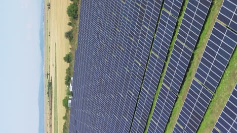 Vertical-Shot-Of-Vast-Solar-Power-Station-With-Solar-Panel-Cells-On-Fields-On-Countryside