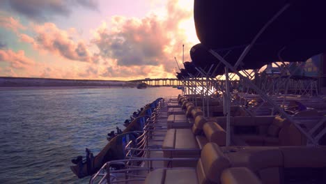 Ein-Wunderschöner-Sonnenuntergang-über-Einem-Hafen-Mit-Ein--Und-Ausfahrenden-Booten