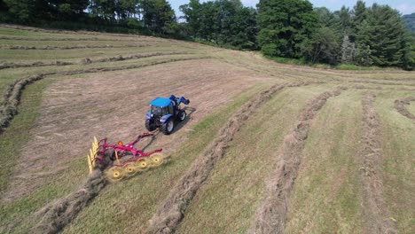 aerial-push-in-to-hay-being-raked-from-tractor-near-boone-nc,-north-carolina