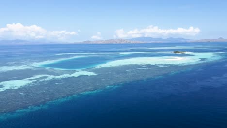 Paluau-Katangan-sandbank-coral-reef-atoll-east-in-Komodo-Island-Indonesia-with-curved-beach,-Aerial-dolly-out-reveal-shot