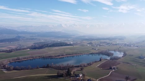 Unglaublicher-Blick-Aus-Der-Vogelperspektive-Auf-Den-Gerzeensee-In-Der-Schweiz-Mit-Wunderschönen-Bergen-Im-Hintergrund,-Schönes-Sonniges-Wetter