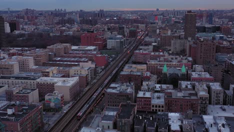 Die-Luftaufnahme-Zeigt-Hochbahnzüge,-Die-Kurz-Nach-Sonnenaufgang-Durch-Harlem,-New-York-City,-Fahren