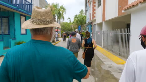 Tour-guide-explains-Boqueron,-Puerto-Rico-history-to-tourist-as-they-walk-down-local-street