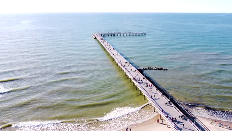 Aerial-static-view-of-Palanga-bridge-with-people-and-calm-Baltic-sea