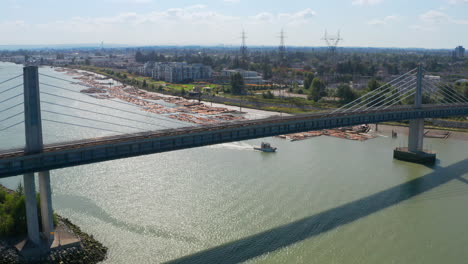 Aerial-View-Of-North-Arm-Canada-Line-Skytrain-Bridge-Over-The-Fraser-River-Between-Richmond-And-Vancouver-In-Canada---drone-shot