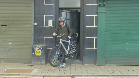 Cyclist-exits-apartment-and-cycles-out-of-frame