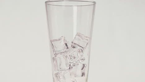 Eiswürfel-Fallen-In-Klares-Glas-Auf-Weißem-Hintergrund