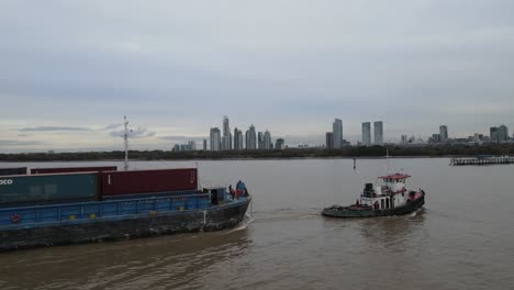 Tiny-fishing-boat-towing-a-massive-cargo-vessel-at-Buenos-Aires