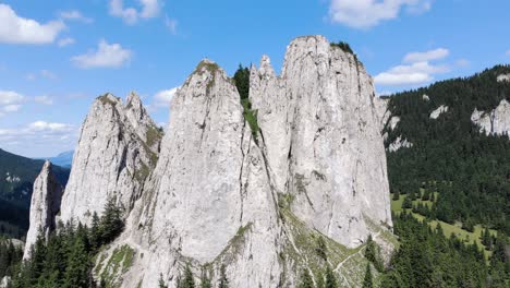 Close-Up-View-Of-Jagged-And-Barren-Mountain-Of-The-Lonely-Rock-With-Evergreen-Forest-In-Romania