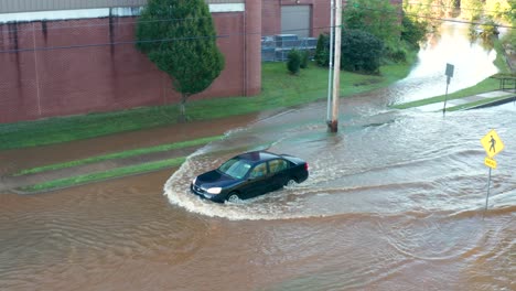 Car-driving-through-flood-waters-on-street
