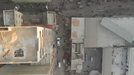 Looking-Down-At-Street-In-Between-High-Rise-Apartment-In-Karachi-With-Birds-Flying