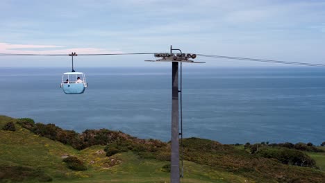 Llandudno-Great-Orme-blue-cable-car-gondola-transportation-tourist-attraction-across-Welsh-scenery-pan-right
