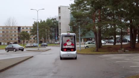 Estonia,-Tallinn,-University-of-Technology,-car-park,-newly-developed-electric-self-driven-mini-bus-going-around-from-back-view