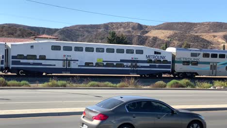 Multiple-Metrolink-train-carriages-passing-Santa-Clarita-Los-Angeles-urban-street-suburbs