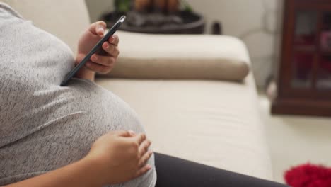 a-young-pregnant-woman-using-a-phone