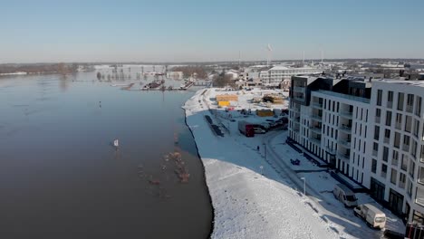 Cityscape-countenance-Noorderhaven-aerial-reveal-of-contemporary-new-luxury-apartment-building-in-bright-snow-mirrored-in-the-high-water-level-in-the-recreational-port-in-the-foreground